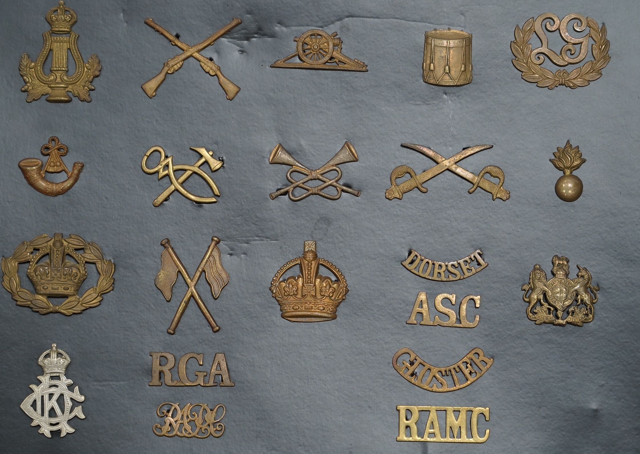 A collection of fifty-eight military cap badges, plus a few shoulder titles, mounted on four boards including; 26th Hussars, Inniskilling Regiment, 3rd Dragoon Guards, the Cheshire Regiment, Loyal North Lancashire, the N